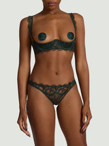 Model wearing a dark green embroidered Coco de Mer lingerie set. Features floral embroidery and silk finishes.