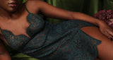 Coco de Mer Isara forest green slip dress made of lace, featuring adjustable straps, delicate scallops, and a slit on the left thigh, shown on model.
