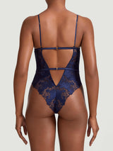 A deep navy blue bodysuit with white floral embroidery, designed with a soft cup shape, silk bands, two adjustable closings at the back and a teardrop cut-out at the chest.