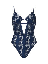A deep navy blue bodysuit with white floral embroidery, designed with a soft cup shape, silk bands, and a teardrop cut-out at the chest.