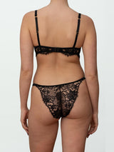 A black Coco de Mer Hera Balcony Bra with intricate Leaver's lace detailing and silk straps shown on model with matching Hera Brazilian Knicker with Leaver's lace and silk