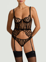An intricate black French Leaver's lace Basque with luxury velvet binding, an underwired design, and adjustable suspender straps, paired with Kiana Skirted Thong