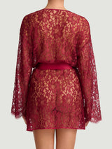 A red lurex leaver's lace robe with a silk belt, designed with wide sleeves and scalloped edges at the neckline and cuffs, shown on model from the back