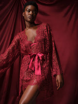 A red lurex leaver's lace robe with a silk belt, designed with wide sleeves and scalloped edges at the neckline and cuffs, paired with matching slip as shown on model