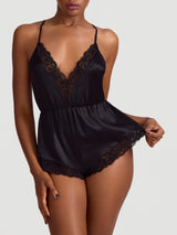 A black silk teddy with corded Leaver's lace trim, featuring a plunging neckline, low V back, and adjustable crossed silk straps. It has a high leg and pleated short design as shown on the model