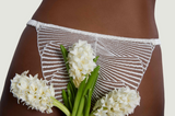 Model wears Athena Ivory Brazilian Knicker with flowers infront.