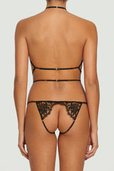 A black Coco de Mer Hera Open Playsuit with intricate French Leaver's lace and silk straps, featuring gold sliders to make it fully adjustable as shown on model