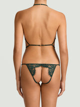 An open playsuit in forest green featuring delicate lace and silk straps, featuring an open design for the breasts and the bum, shown on model.