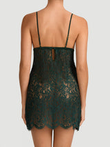 A forest green Coco de Mer Isara slip dress made of lace, featuring adjustable straps, delicate scallops, and a button fasting on the back, shown on model.