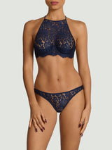 Model wears a UK size M in underwire high neck plunge bra with sapphire lace detailing across the front cascading over silk quarter quarter cups, this is paired with the Brazilian knicker worn in a UK size M.