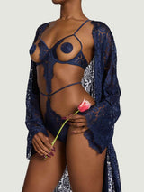 Model wears a UK size M in the underwire open playsuit with scallop edge sapphire lace detailing across the body with silk straps across the waist, legs and shoulders, paired with the sapphire lace robe