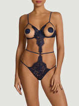 Model wears a UK size M in the underwire open playsuit with scallop edge lace detailing across the front of the exposed chest, silk straps across the waist, leg and shoulder from the front