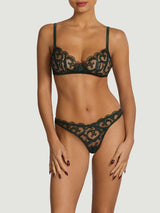 Model wearing a dark green lingerie set from Coco de Mer. Featuring a bespoke floral embroidery on sheer tulle, a soft cup bra shape, Brazilian knicker and silk finishes. 