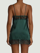 Model showing the back of a Coco de Mer green lingerie silk slip dress.
