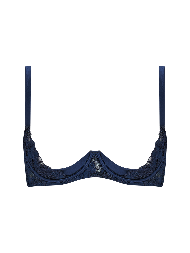 A deep blue quarter cup bra with intricate embroidery along the edges and adjustable straps.