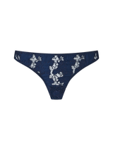 A navy blue Coco de Mer Arella Skirted Thong with delicate blue floral embroidery and scalloped edges.