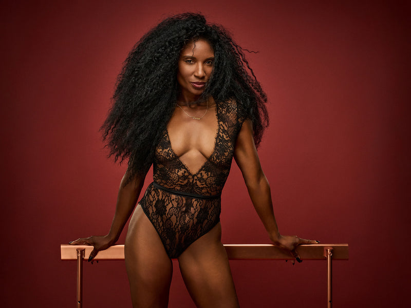 Dame Denise Lewis wearing Coco de Mer's Hera Bodysuit made in a luxurious black Leaver's lace with scalloped hems