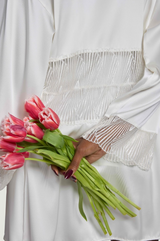 Close up image of model wearing Model wears the ivory silk robe with scallop edge detailing across the sleeve