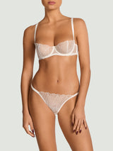 Model wears a UK size 34B in ivory balcony bra with scallop edge embroidery with silk straps from the front, paired with the ivory brazilian knicker with scallop edge emdroidery in a UK size M 