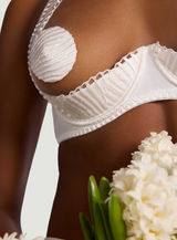 Model wears a UK size M in the ivory quarter cup bra showing scallop edge embroidery detailing against a neutral background close up 