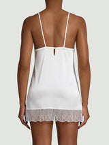 Model wears ivory slip with silk straps and a scallop edge embroidery detail at the bottom from the back 