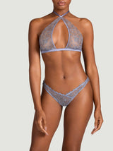 Model wearing the Coco de Mer Esme halter neck soft cup bra and V-front thong in powder blue silk and embroidery.  The embroidery is a sheer geometric floral design. 