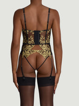 Model wears a UK size M black underwire quarter cup basque with gold embroidery attached to silk suspender straps, paired with black open knickers with gold embroidery and black sheer suspenders
