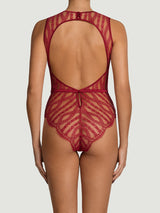 A back view of a model wearing a red scalloped Leaver's lace bodysuit with a silk bound edge open back, eyelash trim, a red silk covered button and a red silk waistband, designed in London and made in Portugal.