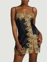 Model wears a UK size M in the black silk slip with gold rose embroidery detailing across the chest and down the front into a slit on the thigh, embroidery then continues throughout the hem with black silk straps 