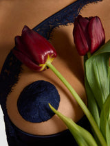Model wears a UK size M in quarter cup bra with exposed chest, sapphire lace scallop edge detailing across the front over the chest attached to silk quarter cups 