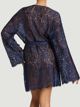 Model wears scallop edge sapphire lace robe with silk tie across tie across the waist from the back 