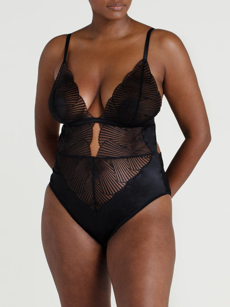 A black Coco de Mer Athena Bodysuit with graphic embroidery and a deep plunging neckline. It includes fan edged cups, an underbust band of jet black silk, adjustable silk straps, and gold hook and loop fastenings